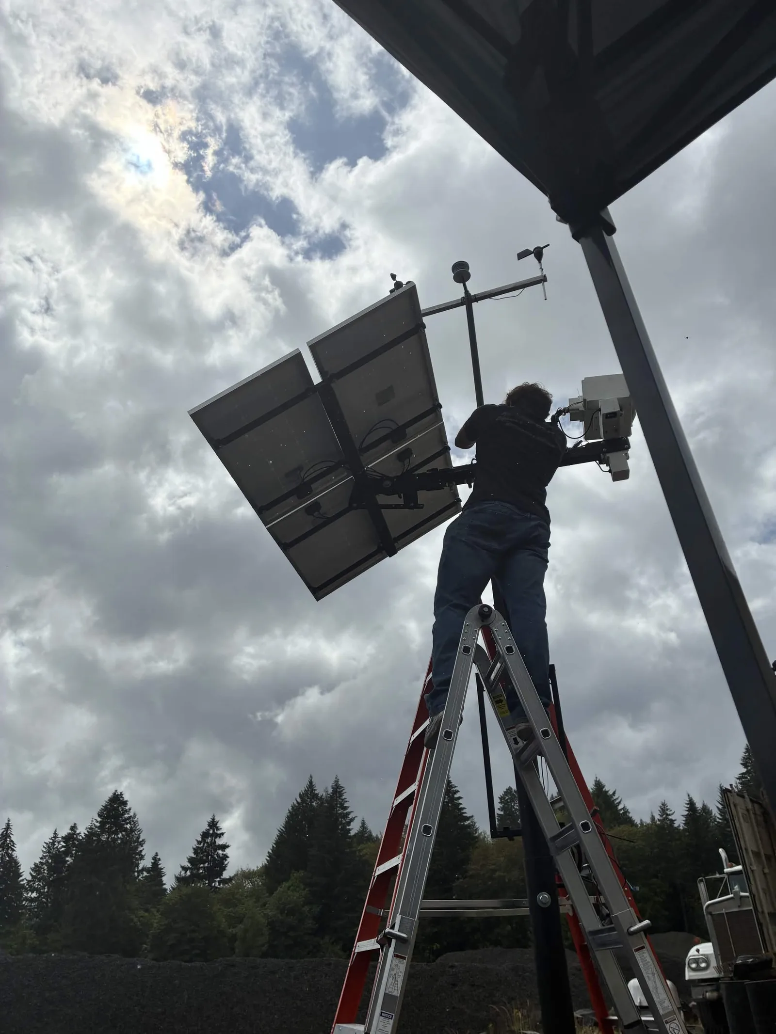 Cascade team member installing a solar-powered monitoring station in the field
